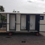 Side view of washroom hut with opened toilet doors and modern black exterior