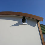 Rear exterior view of washroom hut with timber cladding and countryside surroundings