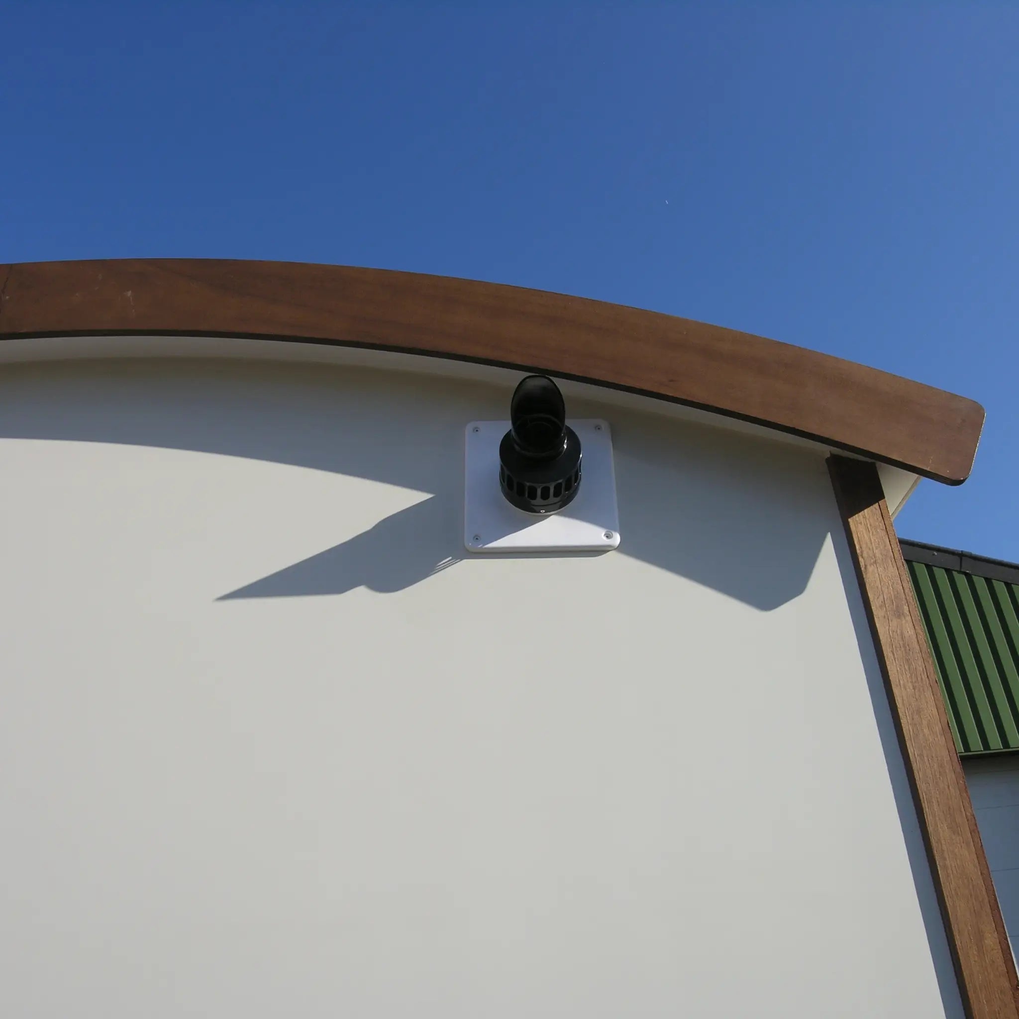 Rear exterior view of washroom hut with timber cladding and countryside surroundings