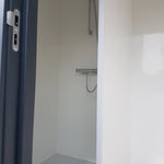 Compact shower area with mounted mixer shower inside luxury washroom hut