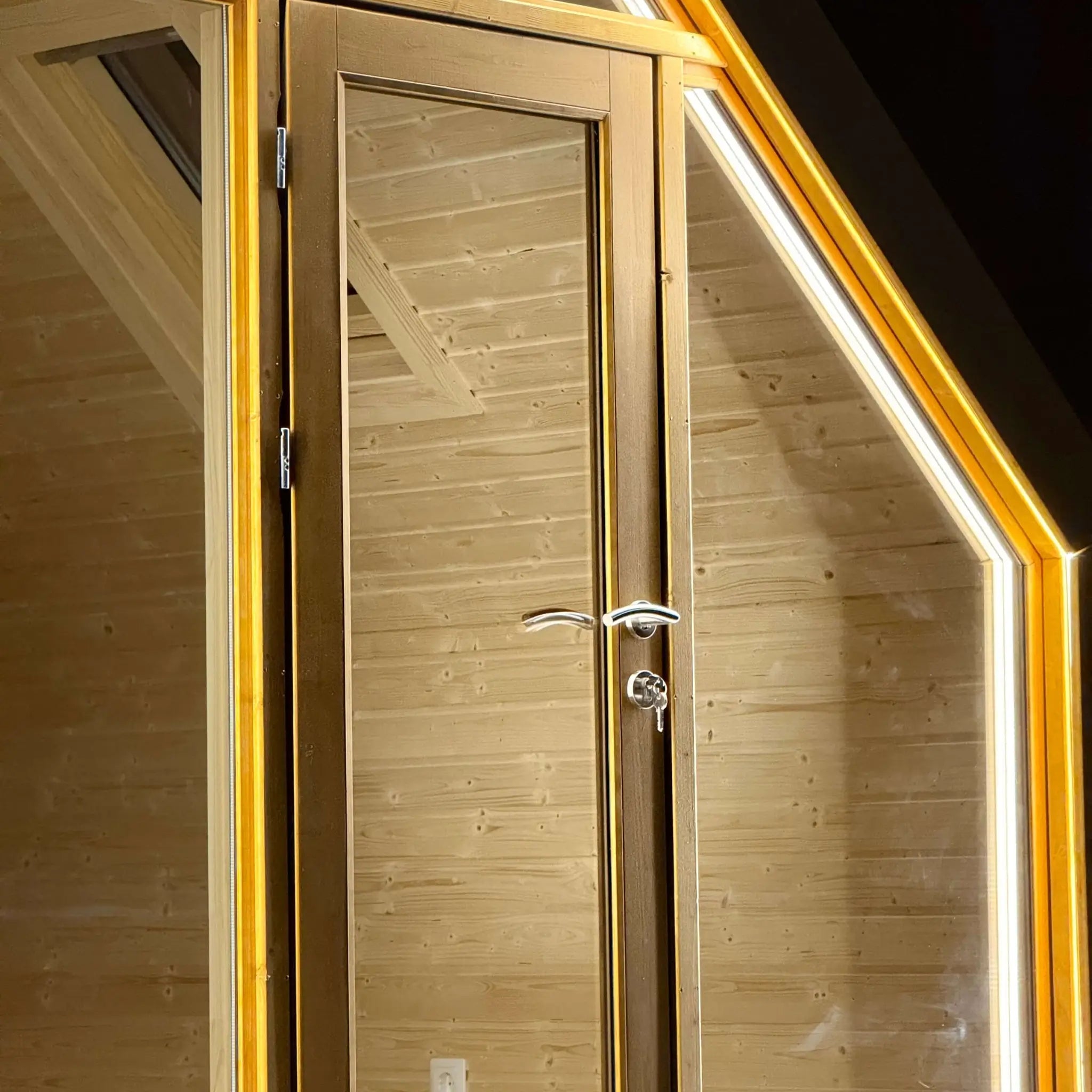 Detailed exterior view of the glazed entrance door on The Ridgefall Pod, highlighting craftsmanship and natural wood finishes.