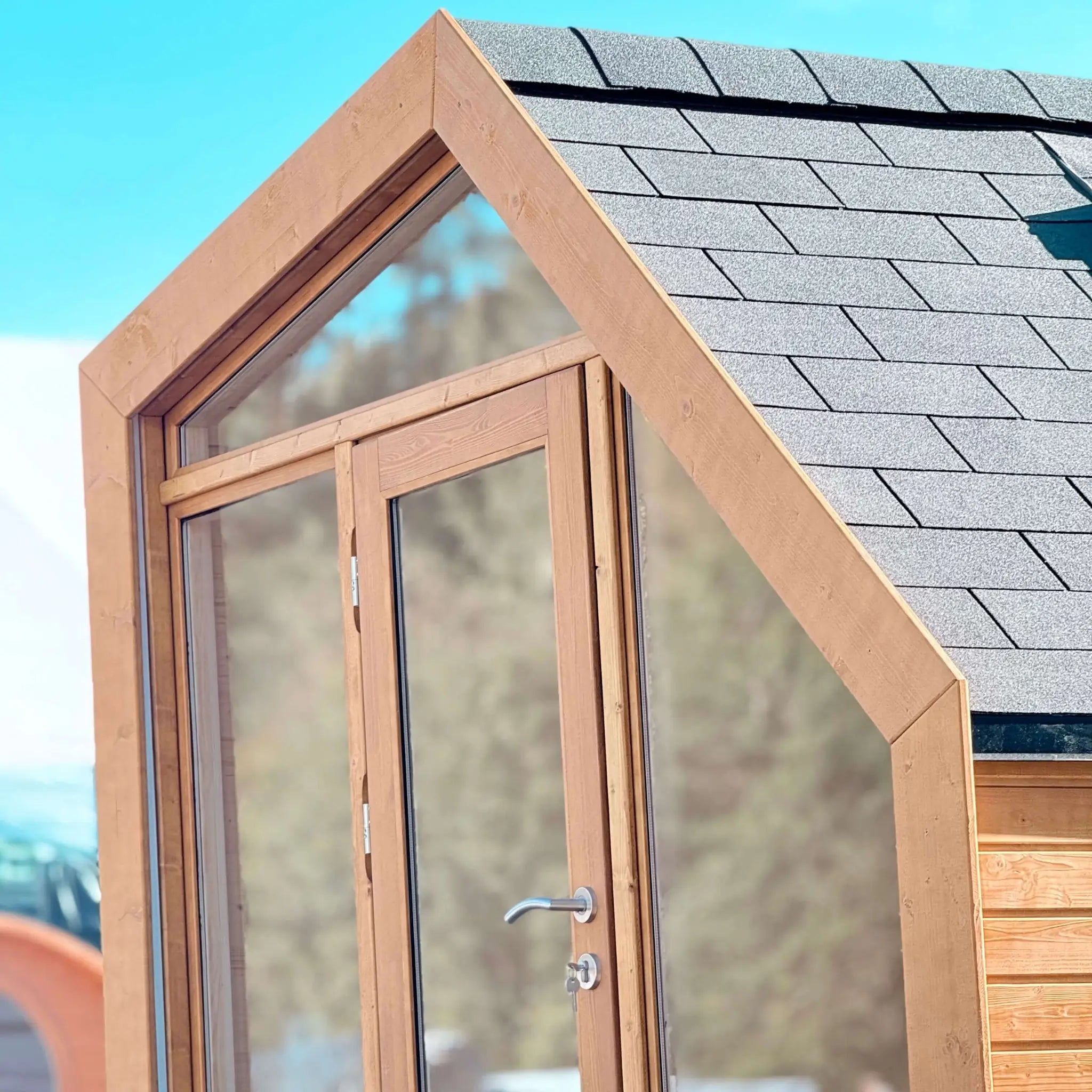 Side exterior detail of The Ridgefall Pod 2 person glamping pod, highlighting timber cladding and clean architectural lines.