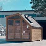 Angled exterior view of contemporary glamping pod with insulated pitched roof, skylight window and floor-to-ceiling glazing.