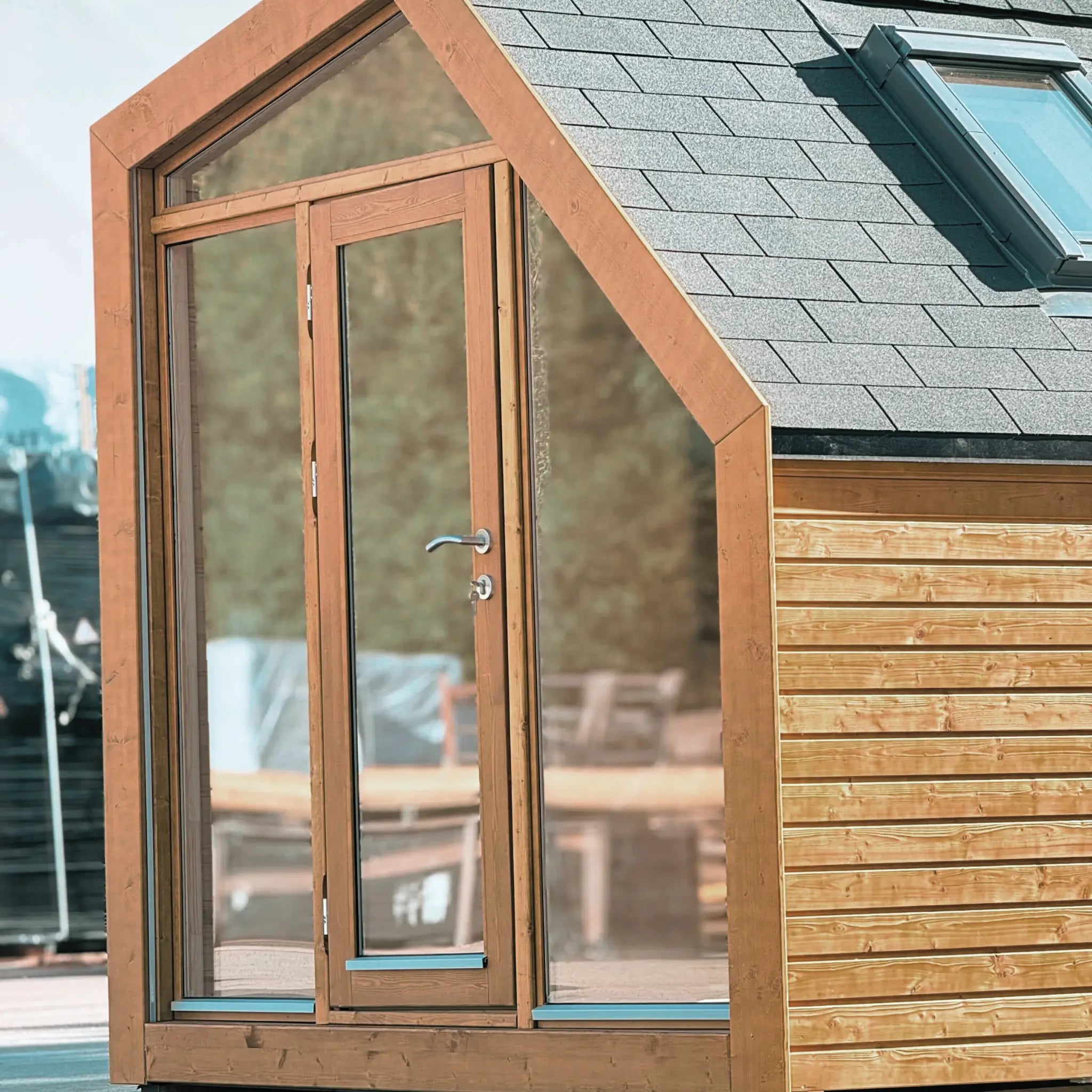 Side exterior view of modern timber glamping pod with insulated roof, compact footprint and contemporary wooden cladding.