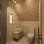 Contemporary bathroom inside compact glamping pod with curved shower cabin, timber interior walls and modern washroom fittings.