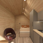 Modern glamping pod interior with compact kitchenette, double bed, recessed lighting and contemporary open-plan living design.
