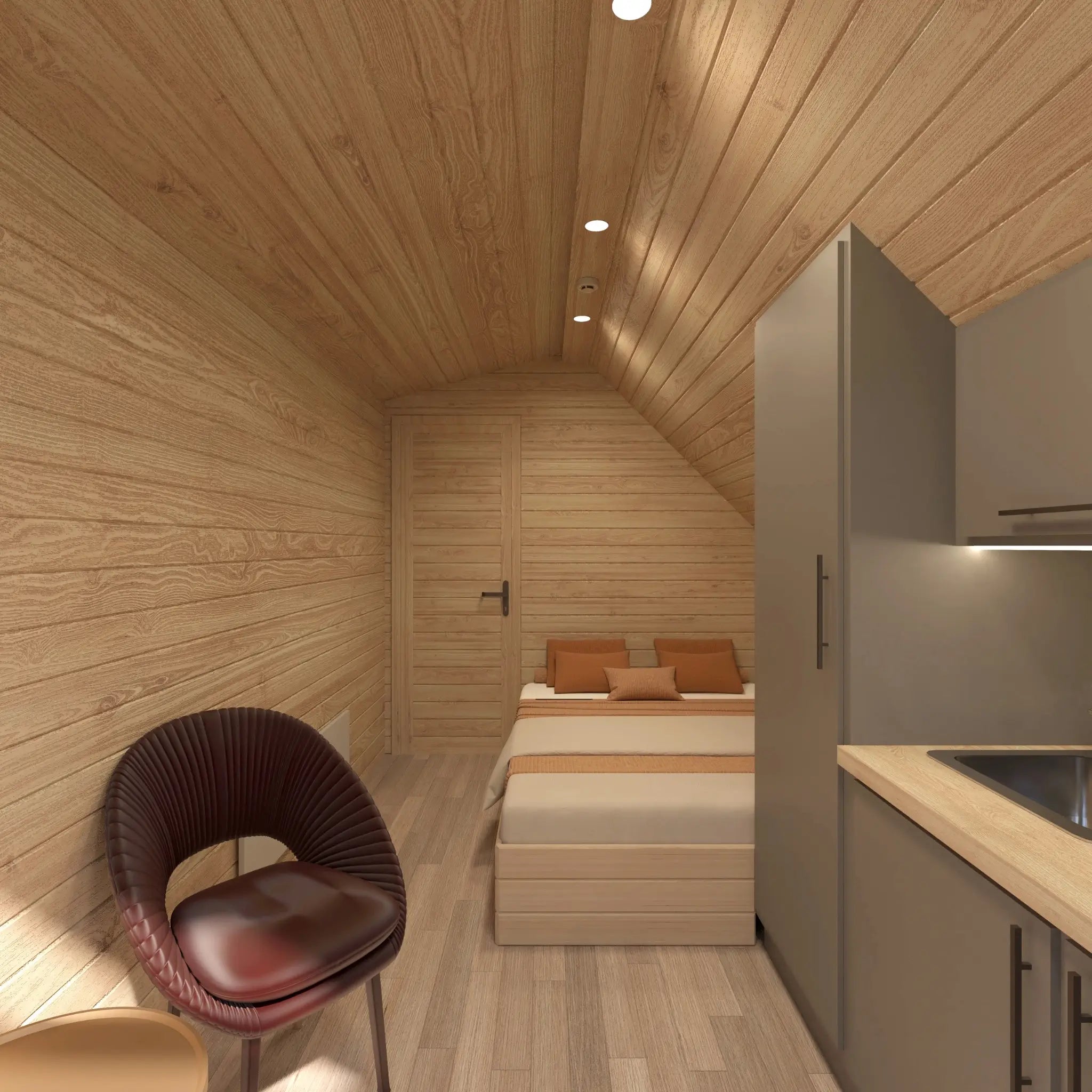 Modern glamping pod interior with compact kitchenette, double bed, recessed lighting and contemporary open-plan living design.