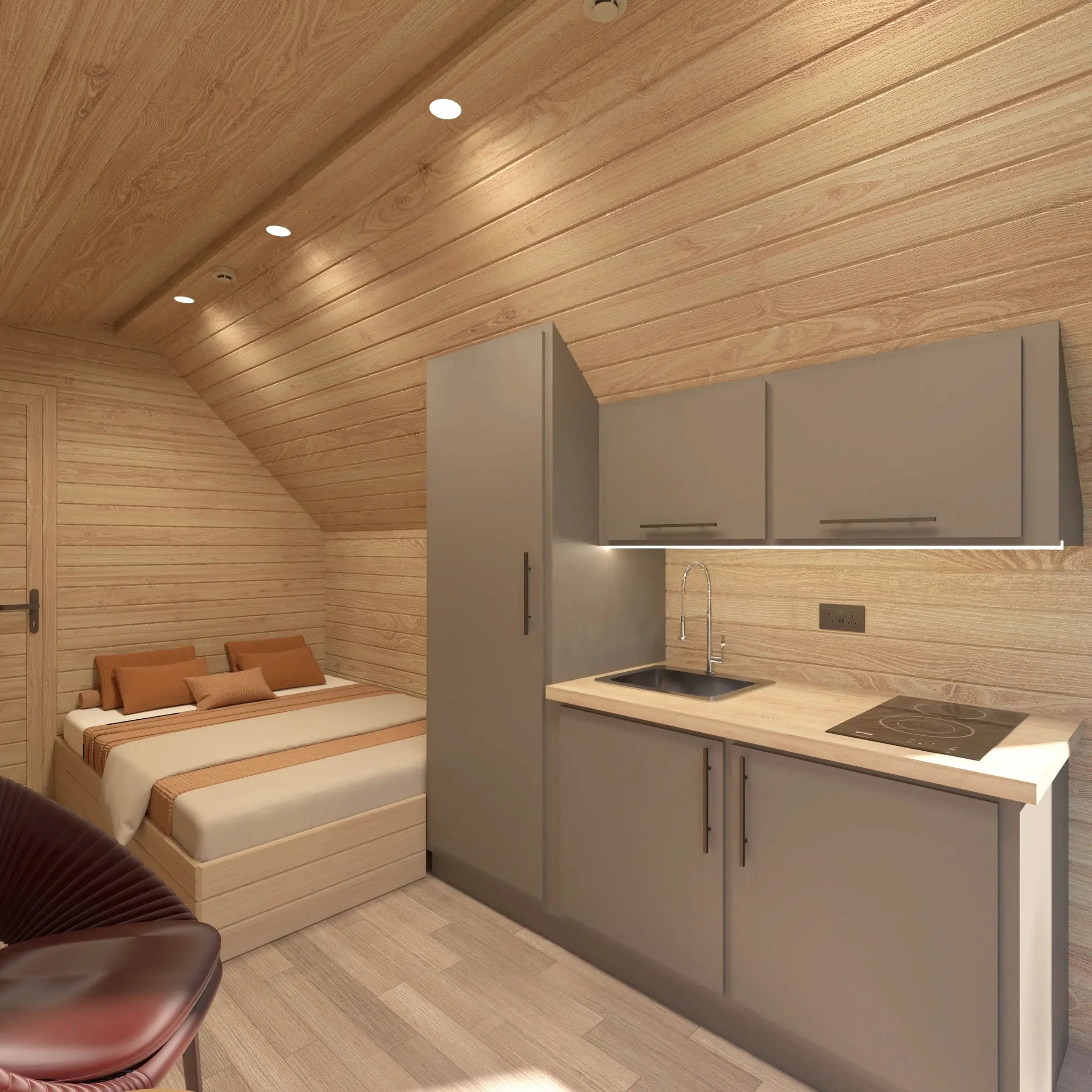 Cozy open-plan glamping pod interior featuring sleeping area, kitchenette and dining chairs.