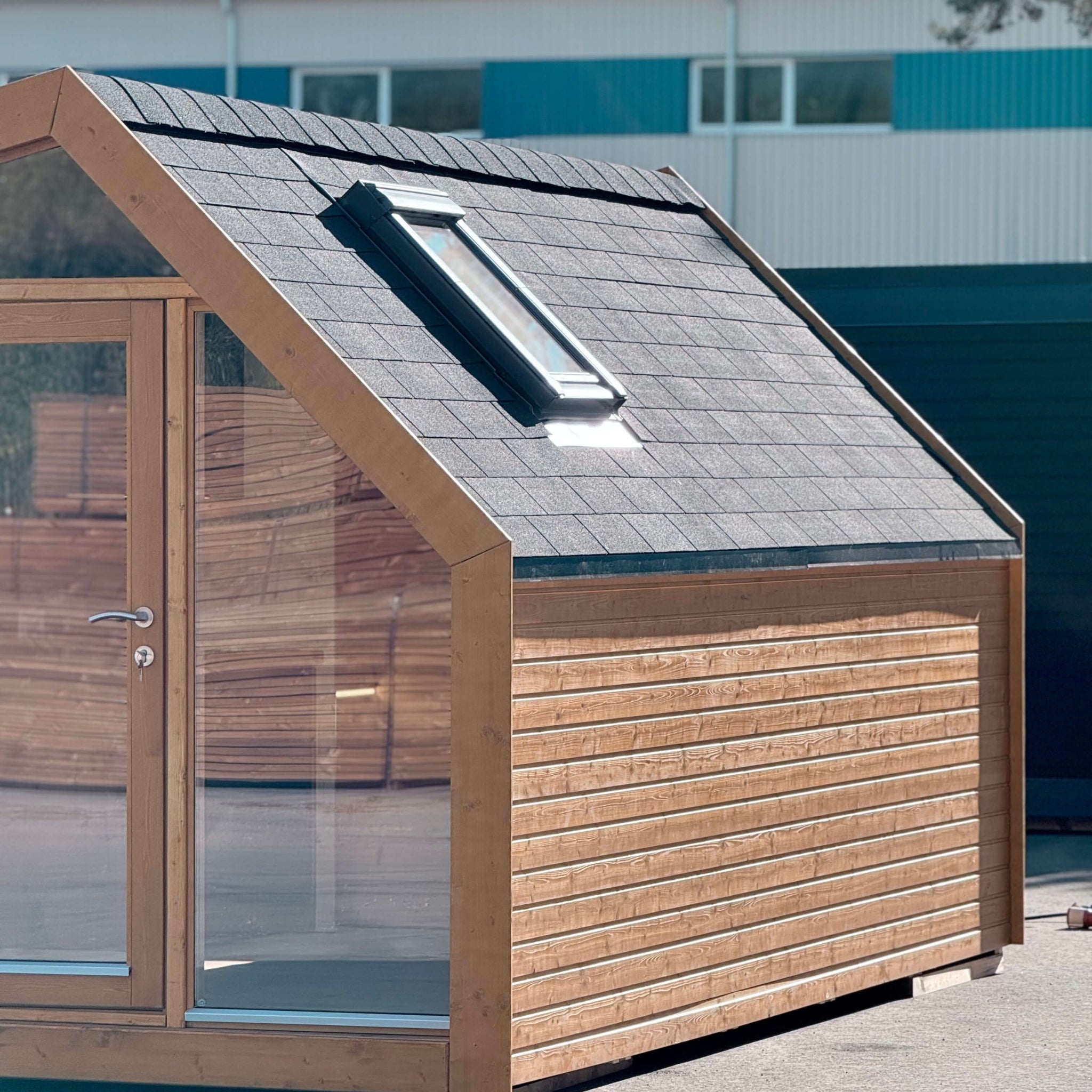 Side view of The Ridgefall Pod 2 person glamping pod, featuring a pitched roof with rooflight and durable timber exterior.