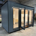 The Small GlampTainer container-style glamping structure – front view with open French doors inviting into a bright, minimalist wooden interior.