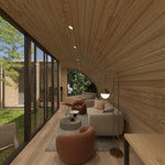 Open-plan living and sleeping area with sofa, lounge chairs, double bed and floor-to-ceiling courtyard glazing inside the ultimate 2 person glamping pod.