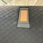 Rear exterior view of The Twilight Pod glamping pod showing black shingle roof and VELUX roof window close-up