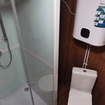 Shower enclosure and toilet layout inside Washwood Barrel with wall-mounted water heater