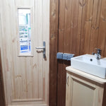 Interior view showing bathroom door, sink unit, and power sockets inside the Washwood Barrel