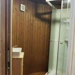 Washwood Barrel bathroom interior with timber walls, sink unit, and shower enclosure