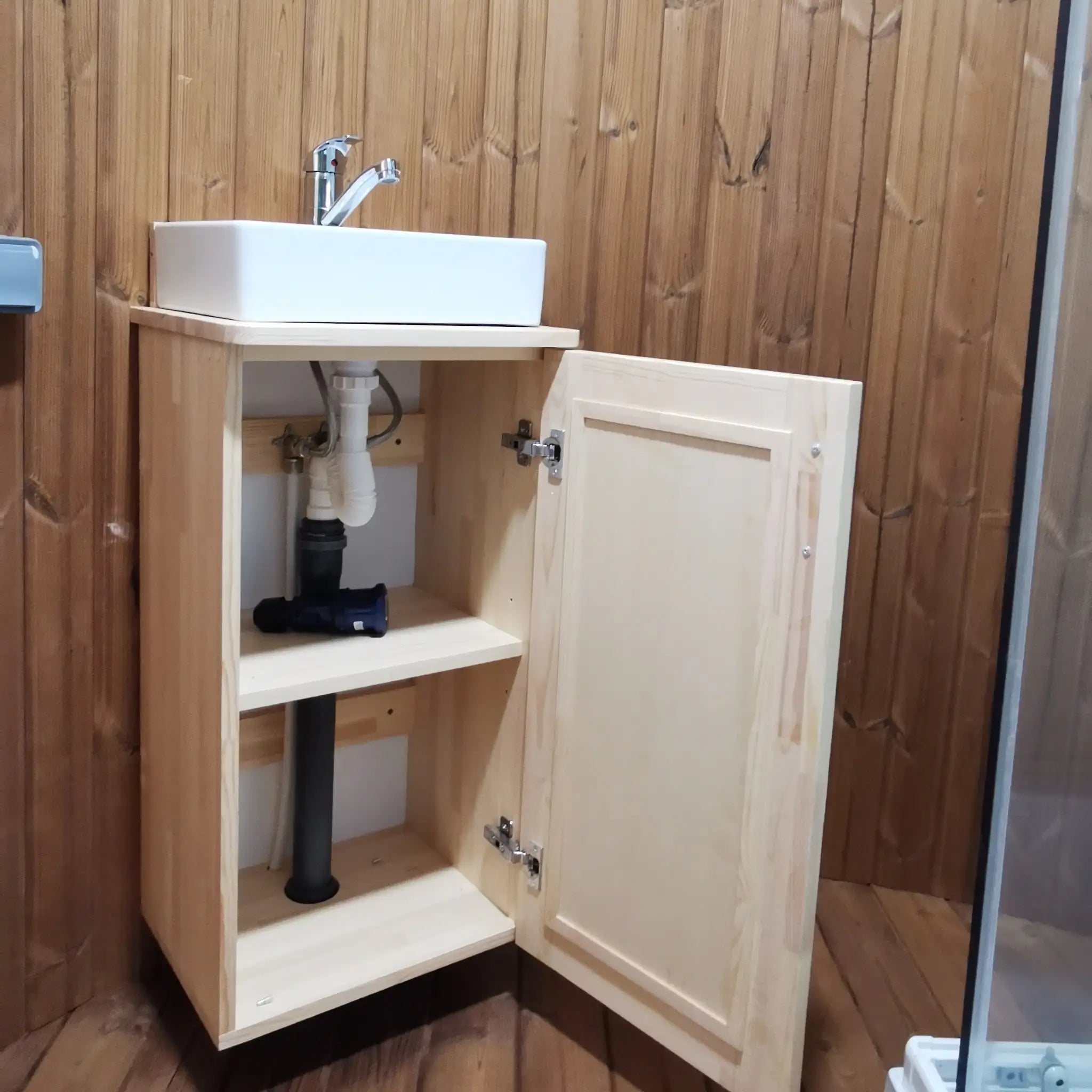 Washwood Barrel sink cabinet with door open showing internal plumbing and storage space