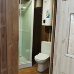 Washwood Barrel bathroom showing shower enclosure and toilet in a narrow layout