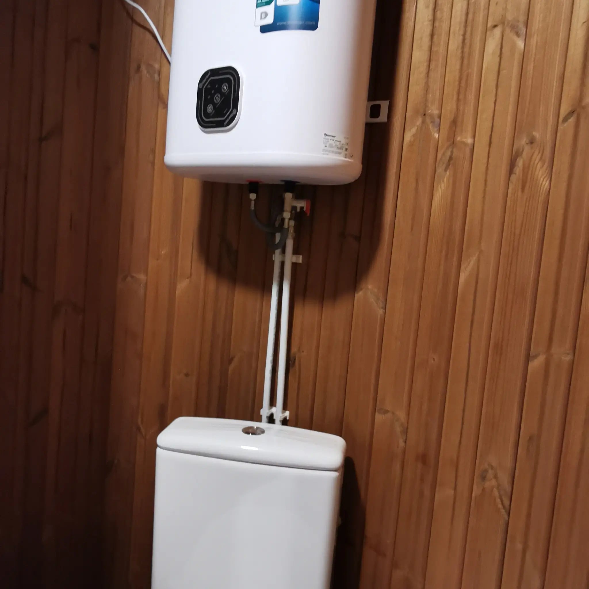 Toilet with wall-mounted water heater inside the Washwood Barrel bathroom