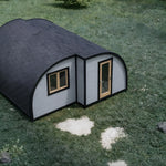 Aerial view of the Dual Halfmoon Pod luxury 2 person glamping pod with curved roof design, timber-framed windows and insulated exterior, set within a natural countryside setting.