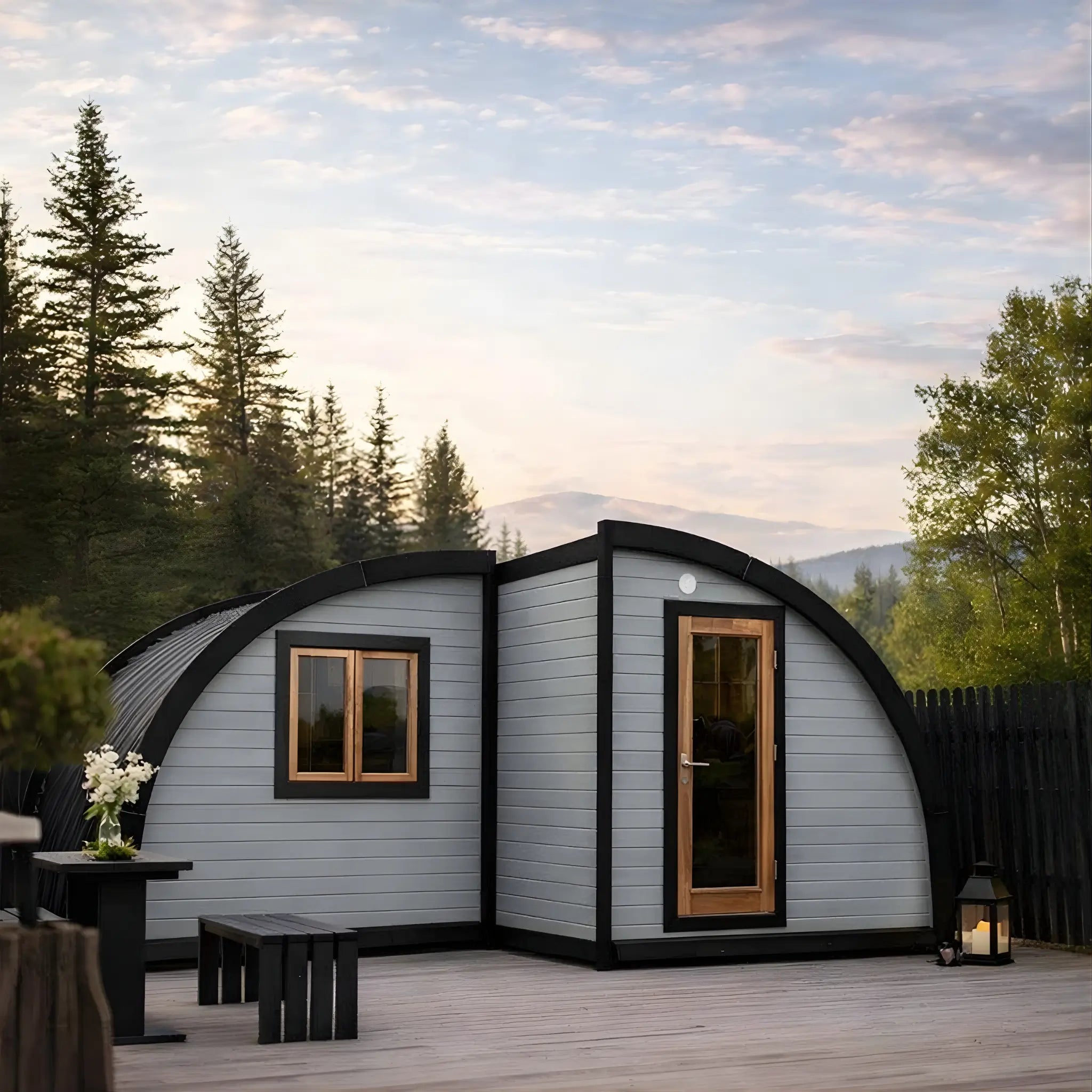 Front exterior view of the Dual Halfmoon Pod, a luxury 2 person glamping pod with panoramic window, curved black roof, modern timber door and contemporary cladding, ideal for boutique glamping sites.