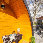 Covered porch seating area of The Dual Halfmoon luxury 4 person glamping pod with sheltered outdoor entrance