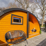 Left exterior view of The Dual Halfmoon luxury 4 person glamping pod showcasing curved roof, timber cladding and covered porch