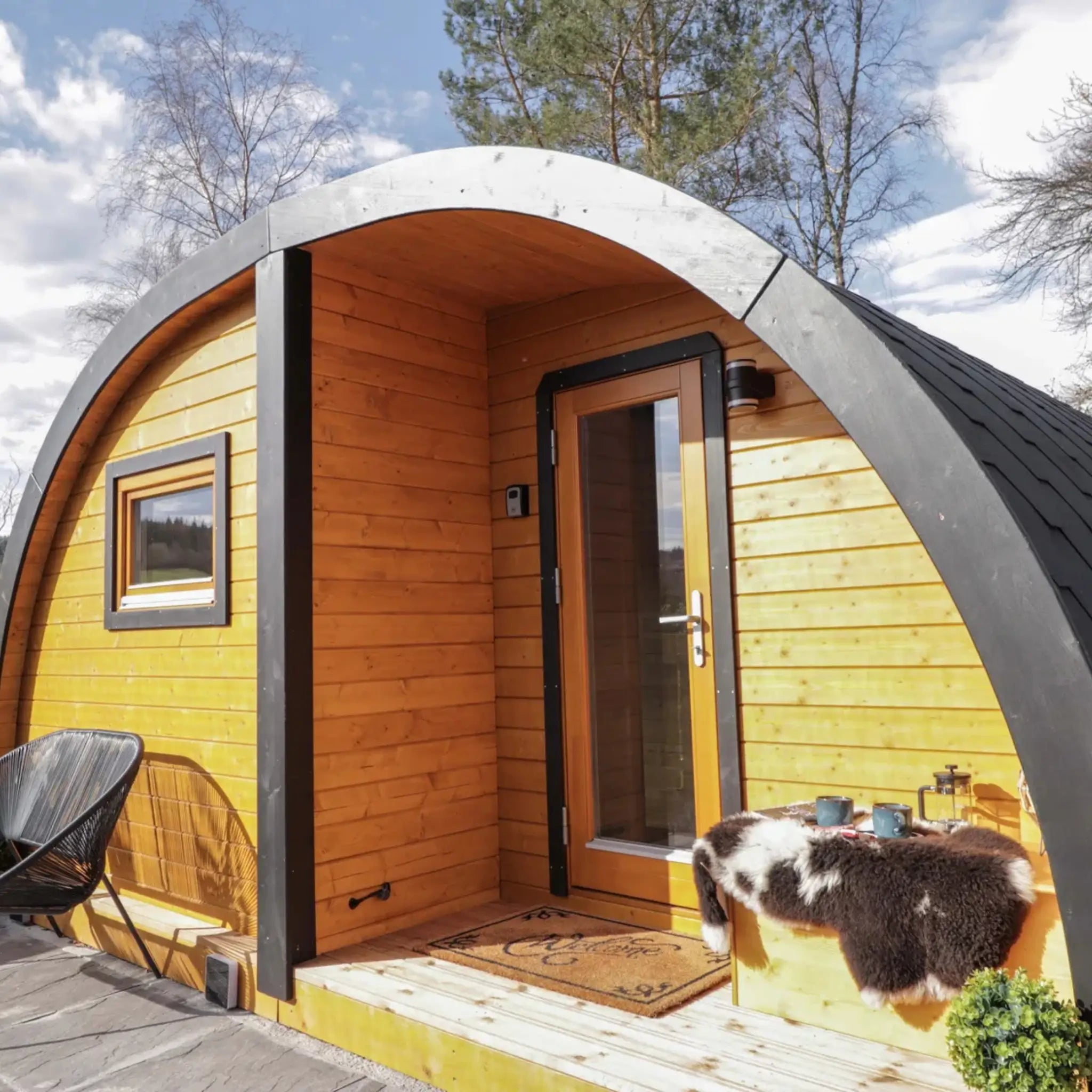Right exterior view of The Dual Halfmoon luxury 4 person glamping pod with glazed entrance, curved roof and timber exterior