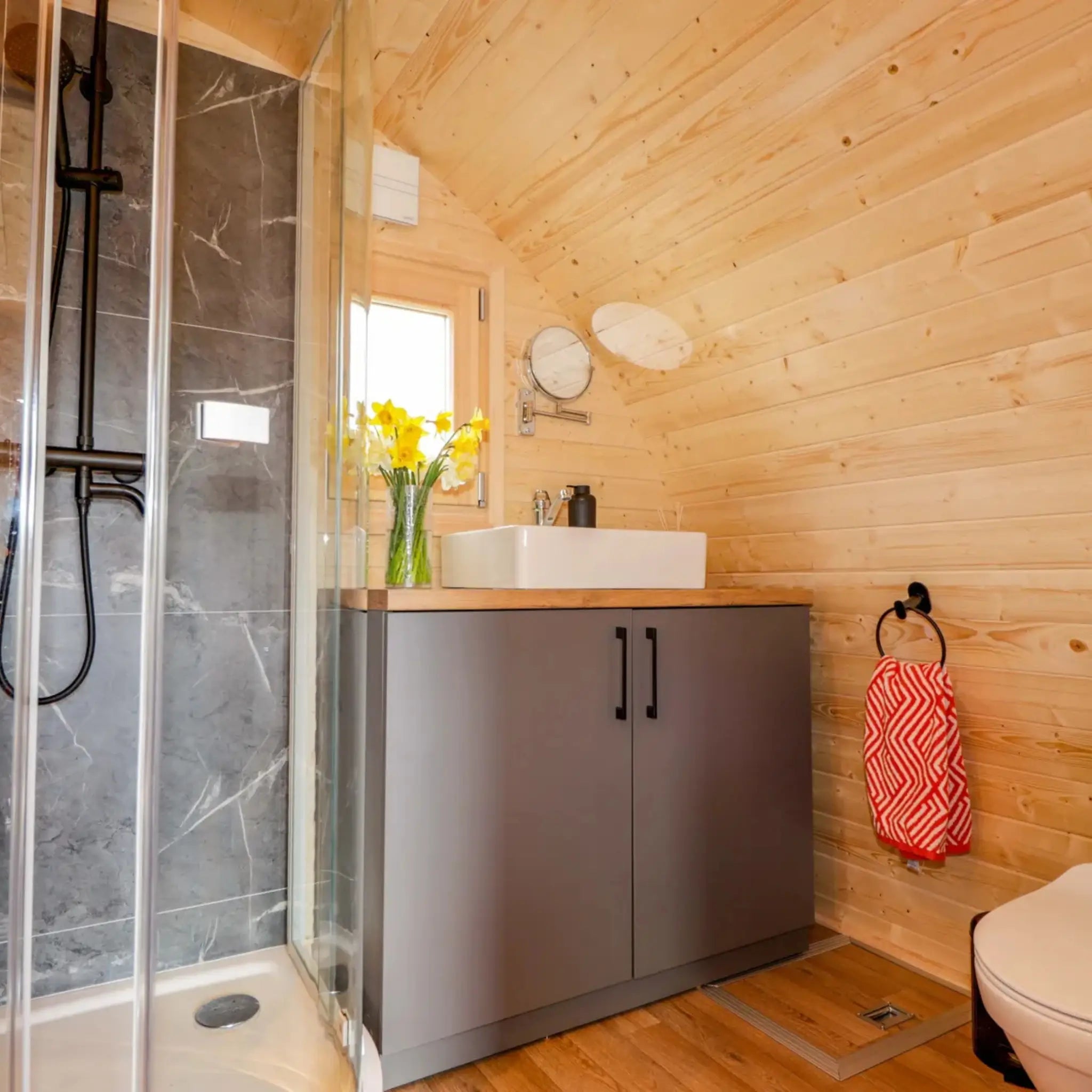 Modern bathroom inside The Dual Halfmoon luxury 4 person glamping pod with shower enclosure, vanity unit and toilet