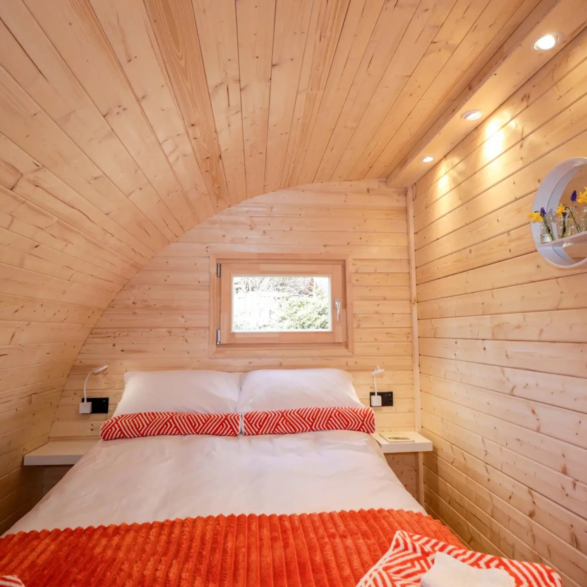 Bright double bedroom in The Dual Halfmoon luxury 4 person glamping pod featuring curved timber ceiling and large bed