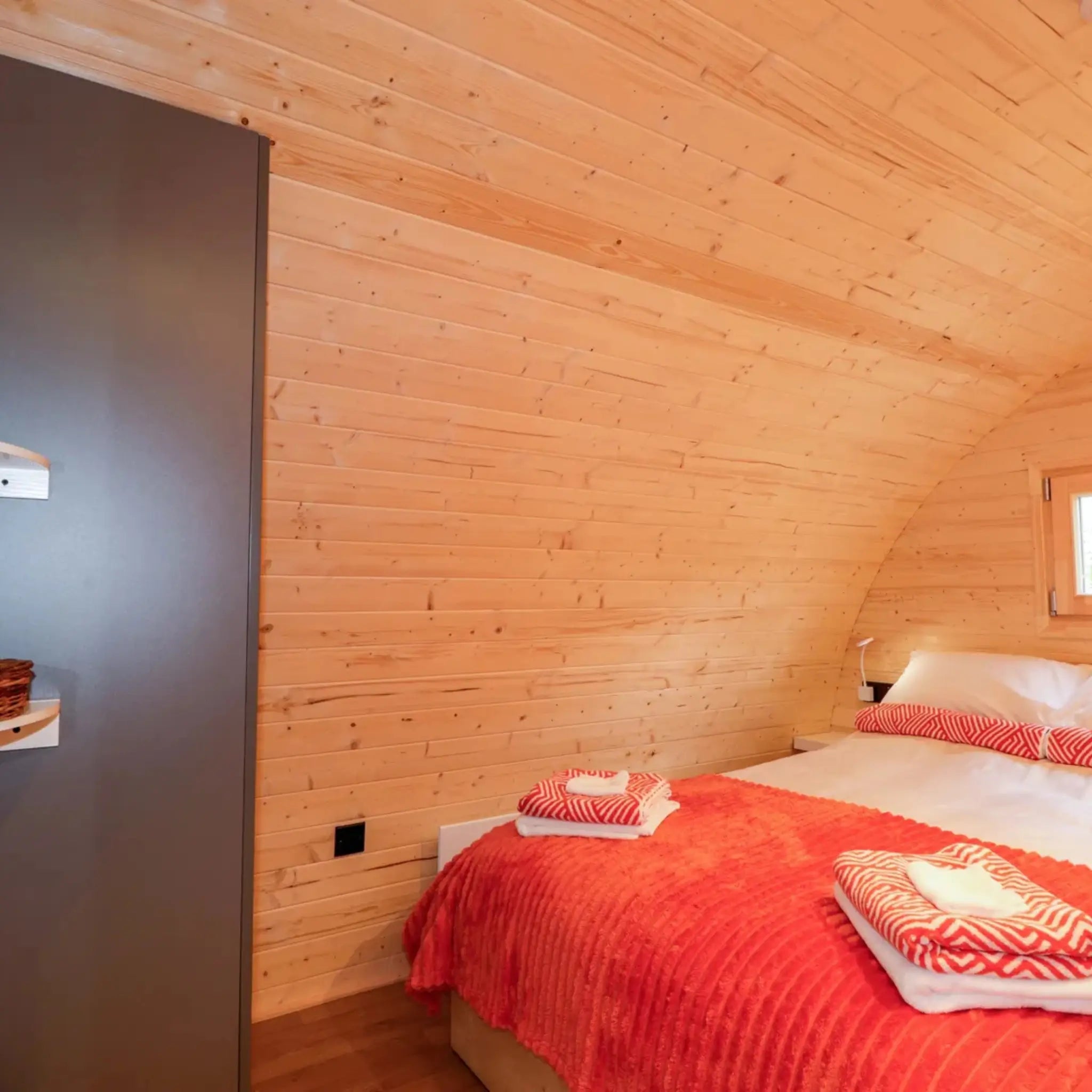 Double bedroom inside The Dual Halfmoon luxury 4 person glamping pod with built-in wardrobe and timber interior