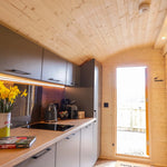 Entrance hallway and modern kitchenette inside The Dual Halfmoon luxury 4 person glamping pod with integrated appliances