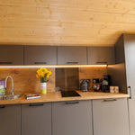 Fully equipped kitchen in The Dual Halfmoon luxury 4 person glamping pod with integrated sink, induction hob and storage