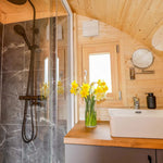 Luxury bathroom vanity and shower inside The Dual Halfmoon luxury 4 person glamping pod with contemporary finishes