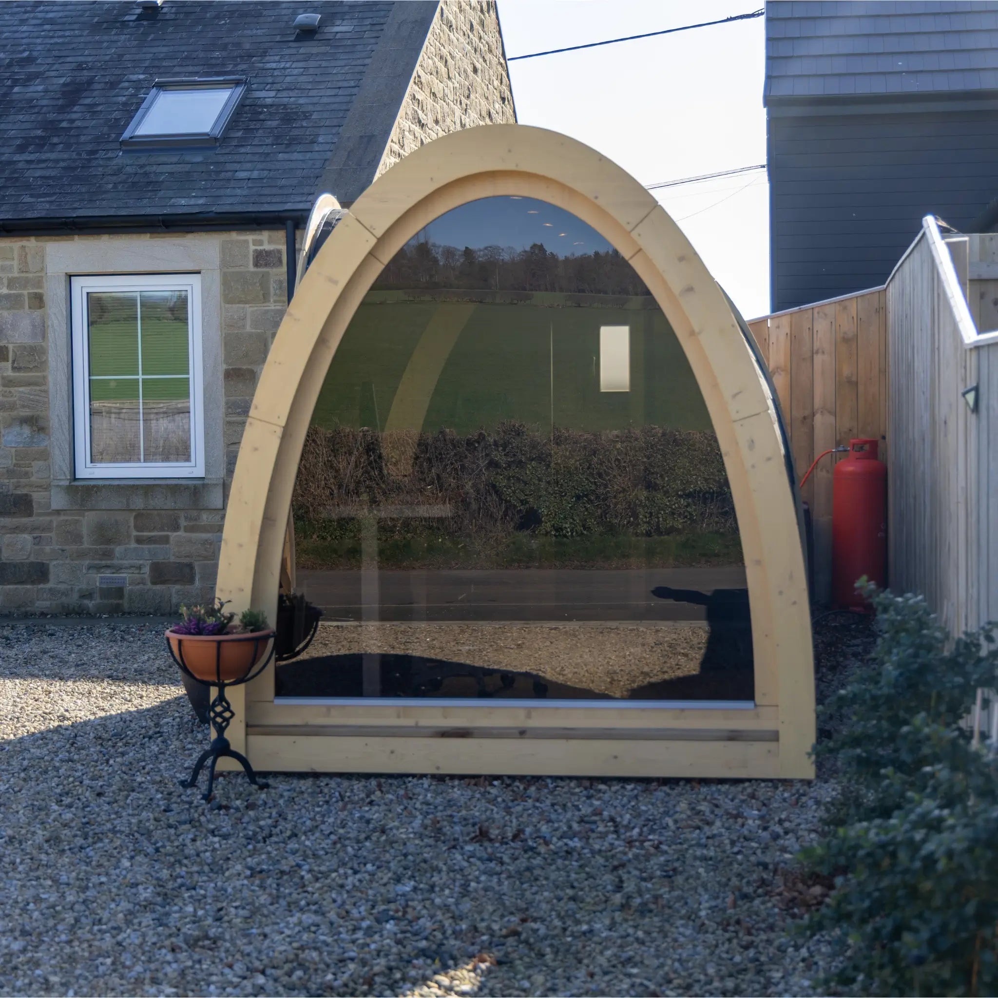 Hobbit garden pod with full glass panoramic end wall, natural wood frame and curved roof, ideal outdoor office or studio
