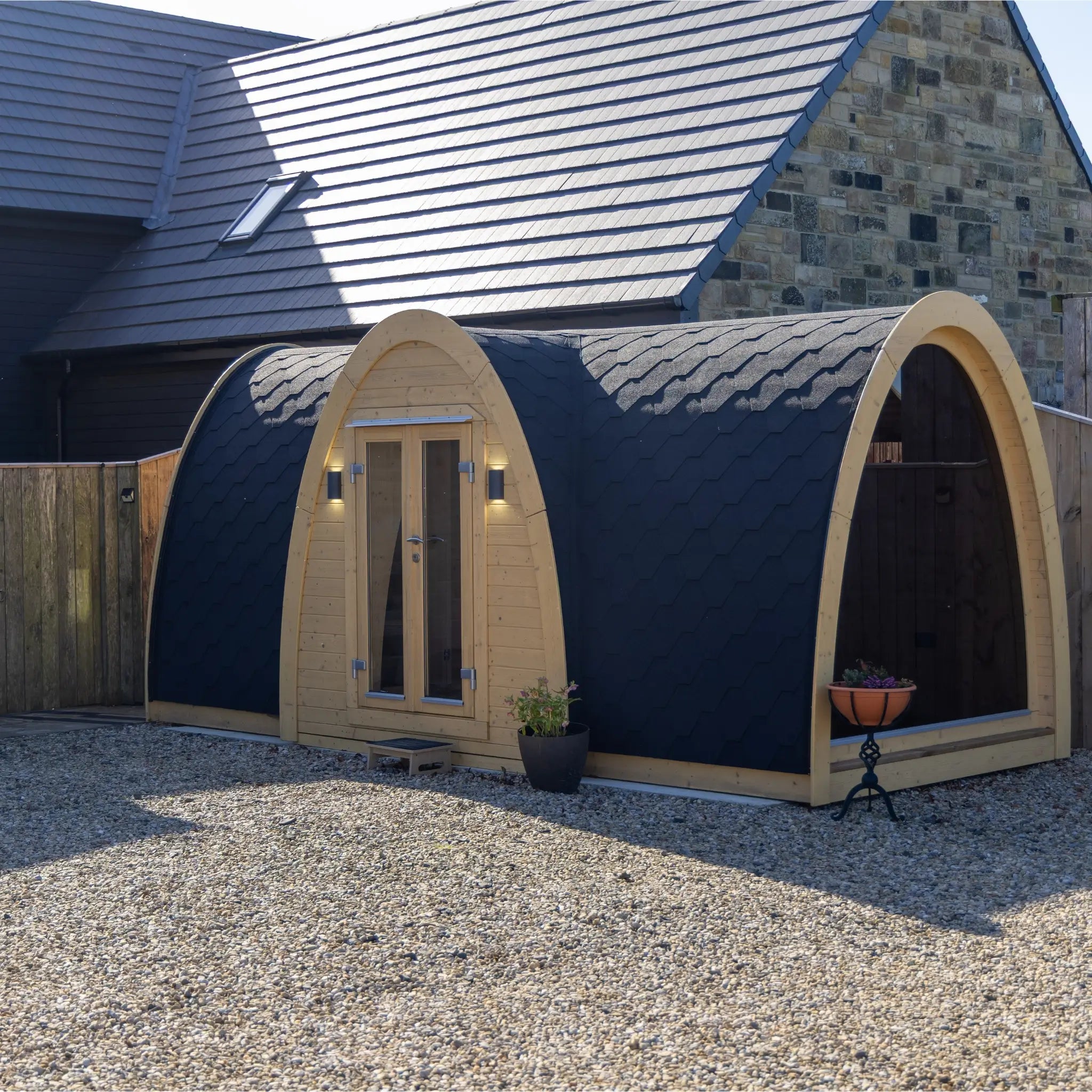 Hobbit pod side angle with full glass end wall offering panoramic countryside views and modern garden office design