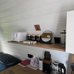Kitchen shelf with toaster, coffee station and storage jars inside Hobbit glamping pod interior