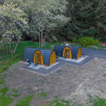 Two luxury timber glamping pods in a peaceful forest setting