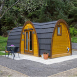 Exterior side view of the luxury 2 person Hobbit glamping pod with timber cladding and arched roof design