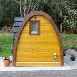 Side view of luxury glamping pod with curved roof and panoramic rear window