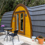 Exterior close-up showing timber entrance, lighting and curved roof design