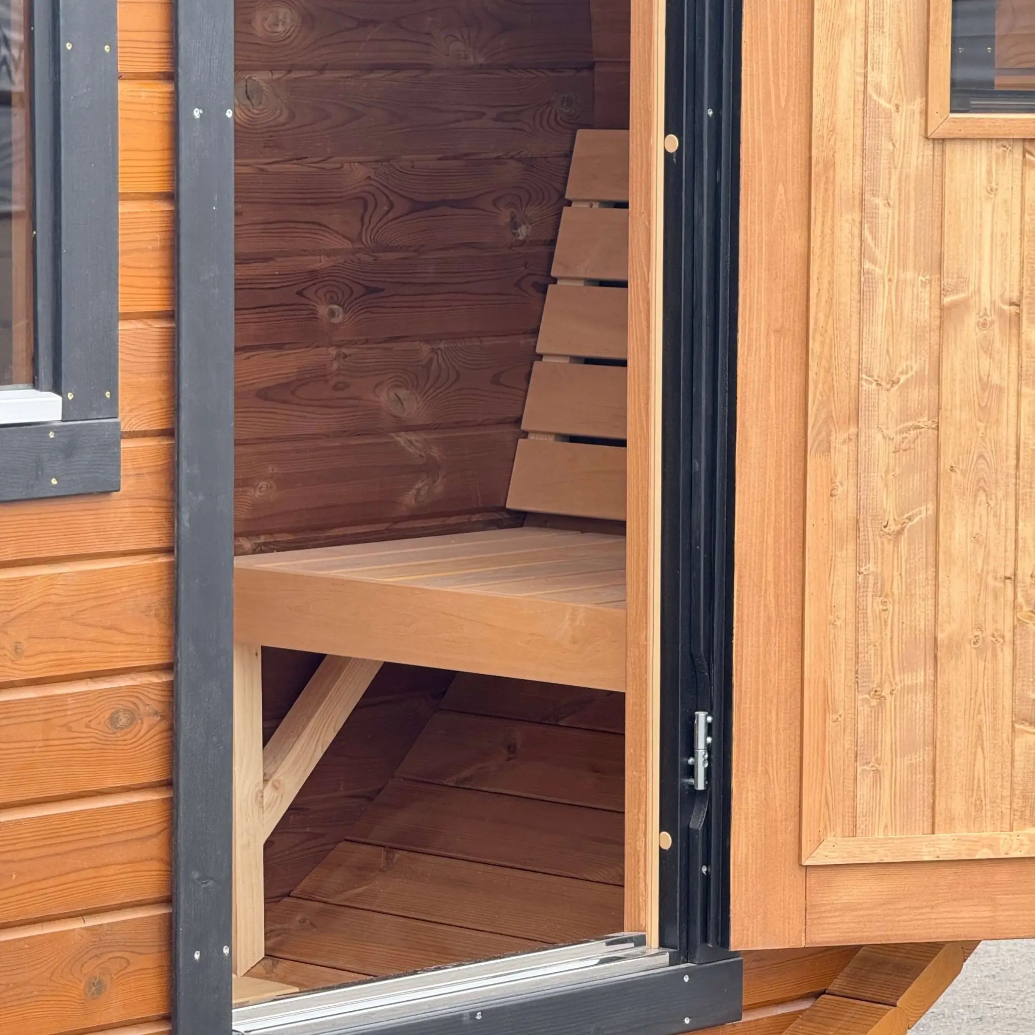 Bench seating inside the changing room of the Infinity Glass luxury 8 person barrel sauna