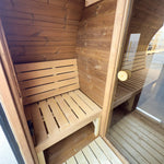 Timber bench seating inside the luxury barrel sauna changing room with glass internal door