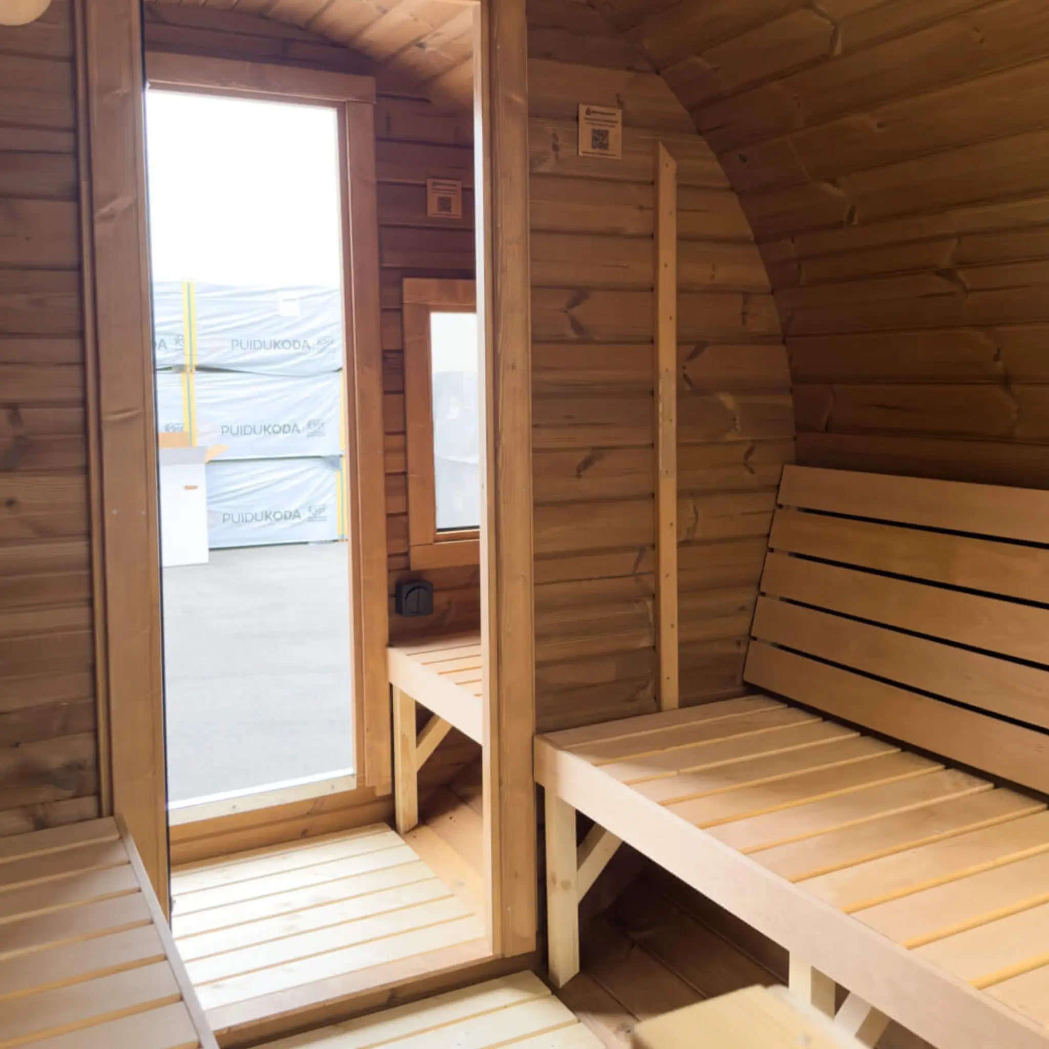 View from the sauna room towards the glass door and separate changing room in the Infinity Glass barrel sauna