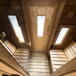 View from the sauna room towards the changing room with glass door and entrance to the barrel sauna