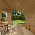 Sofa and dining table area inside the Moonburrow Pod luxury 2-person glamping pod, designed to maximise natural light and panoramic outdoor views.