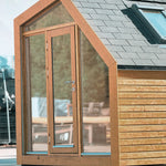 Side exterior view of The Ridgefall Pod, a 2 person glamping pod with horizontal timber cladding and integrated LED lighting.