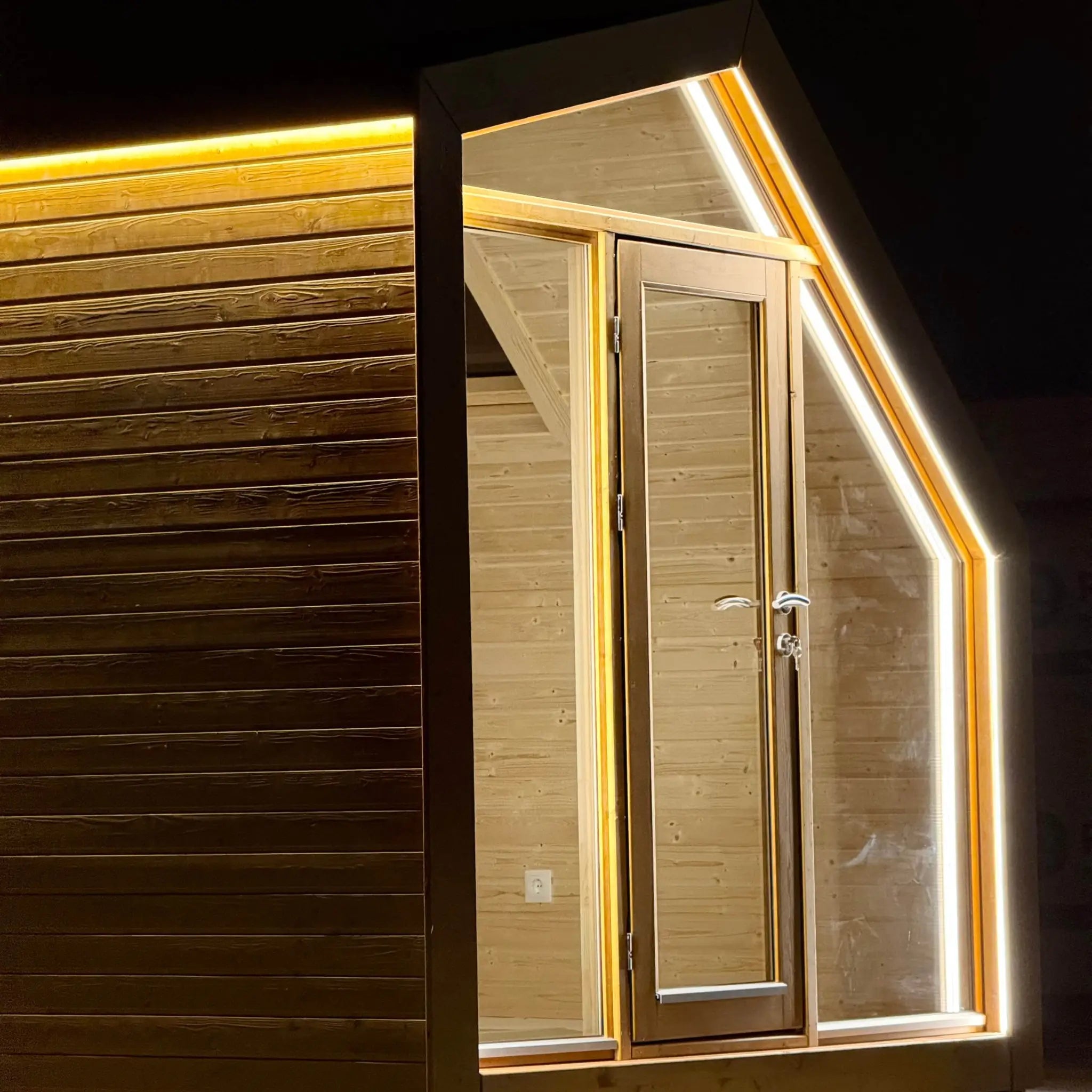 Close-up of the front entrance on The Ridgefall Pod 2 person glamping pod, featuring glazed timber doors and warm LED perimeter lighting.