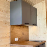 Kitchenette with wall-mounted cabinets and LED under-cabinet lighting inside The Ridgefall Pod 2 person glamping pod.