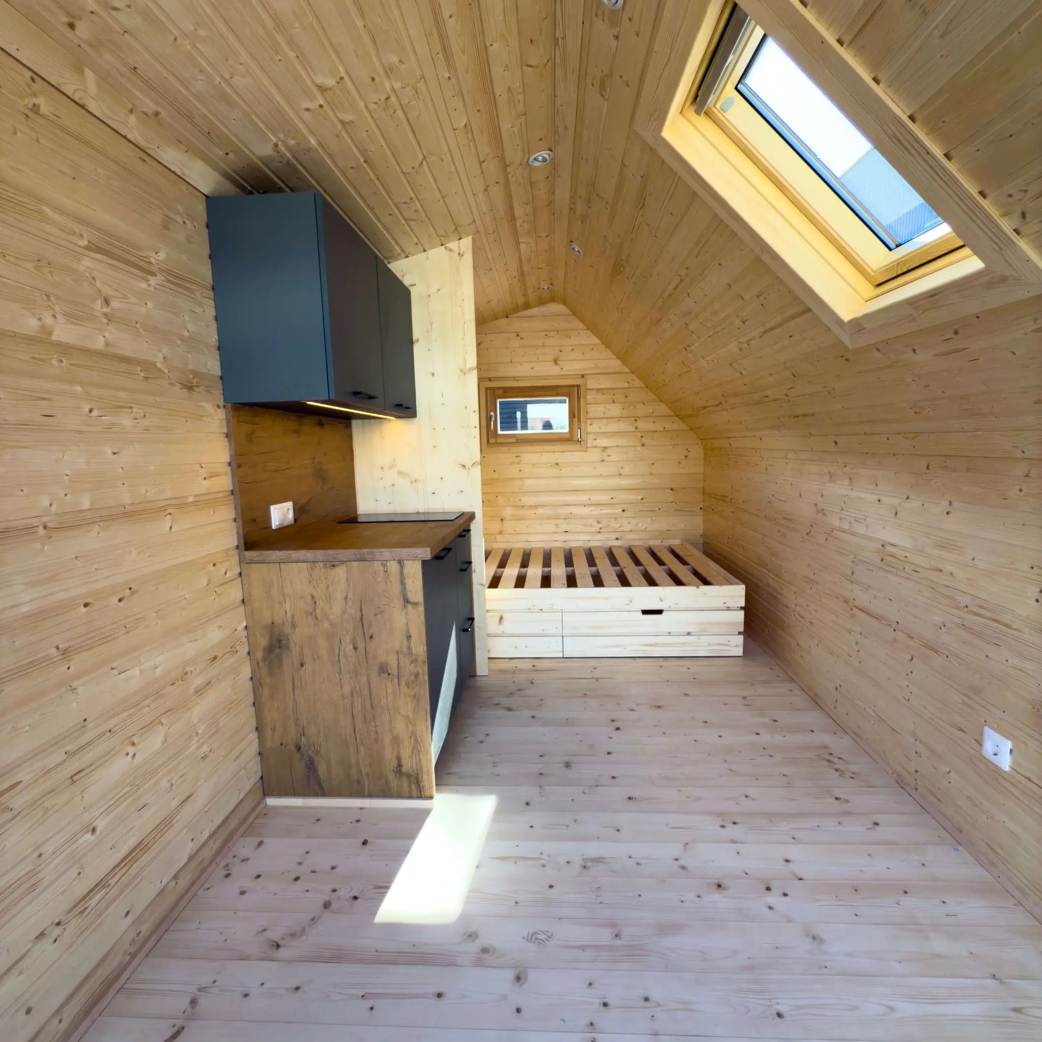 Angled interior view of The Ridgefall Pod 2 person glamping pod showcasing efficient layout and natural wood finish.