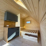 Wide interior view of The Ridgefall Pod 2 person glamping pod highlighting sleeping area and pitched timber ceiling.